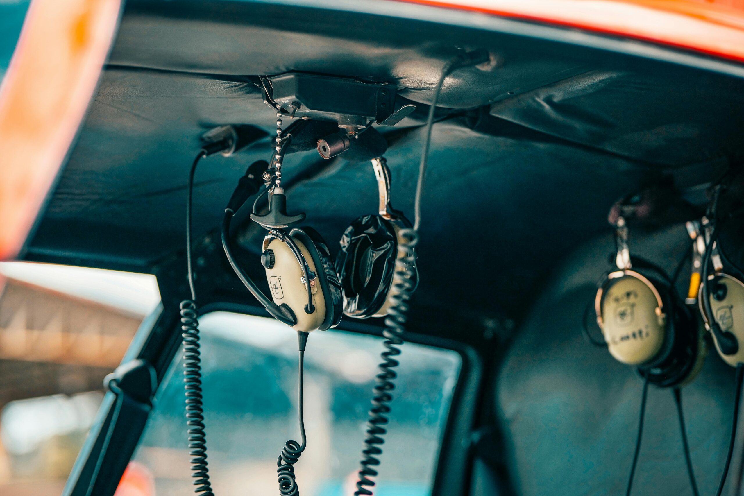 Close-up of aviation headsets hanging in an airplane cockpit, showcasing cockpit technology.